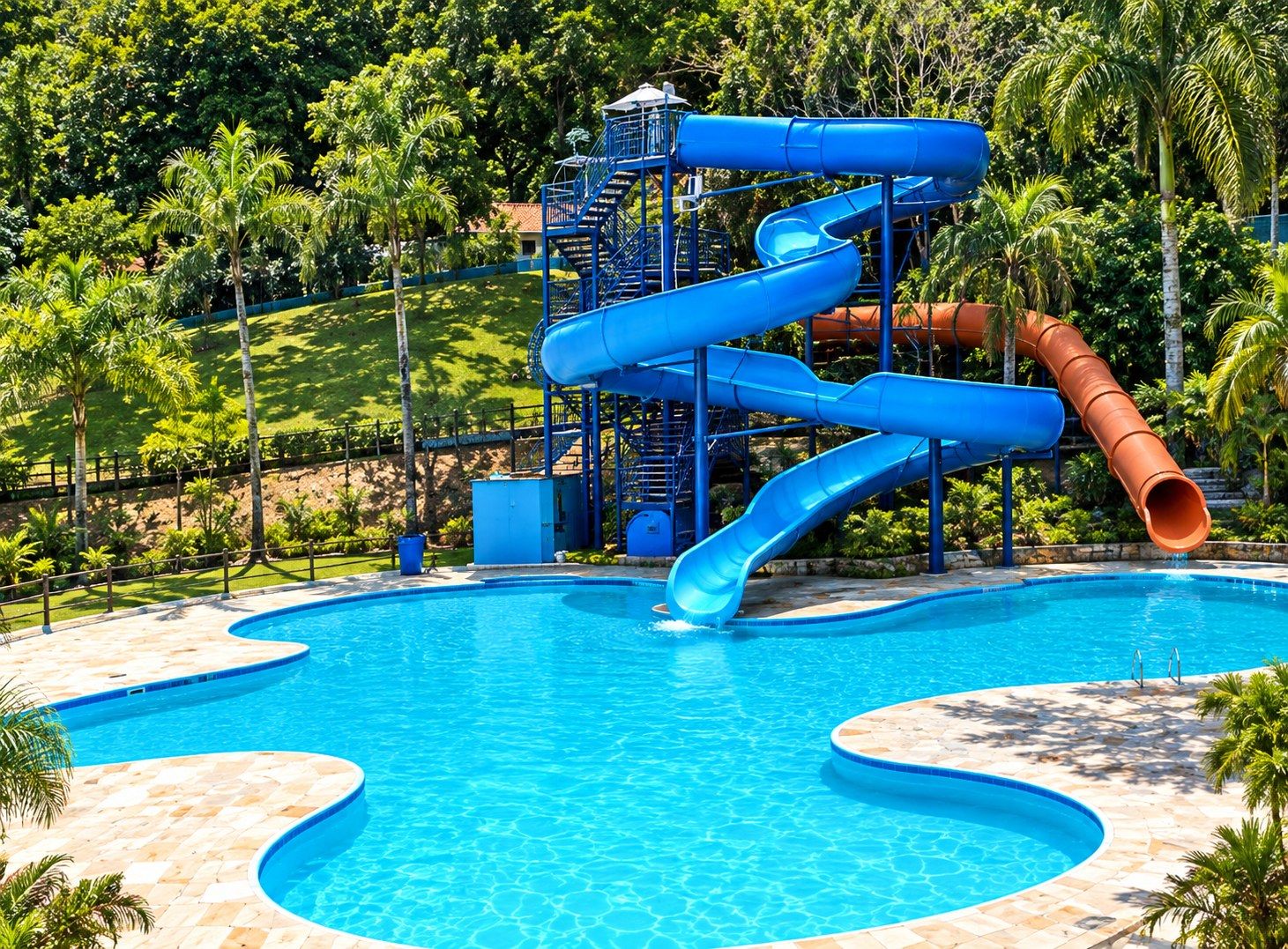 Tobogã em espiral sobre a piscina, cercado de palmeiras